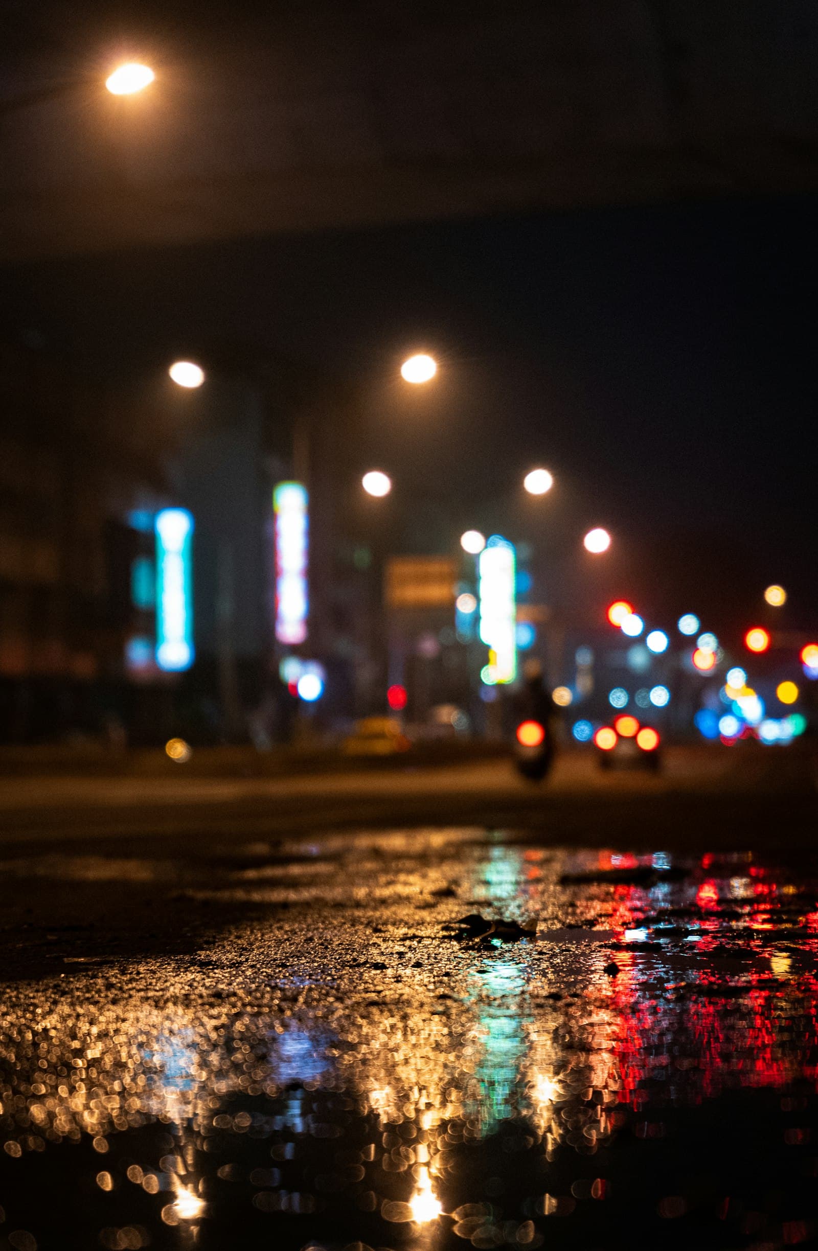 Street lights reflecting on wet pavement at night